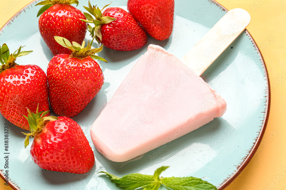 Plate with sweet strawberry ice-cream popsicle on yellow background