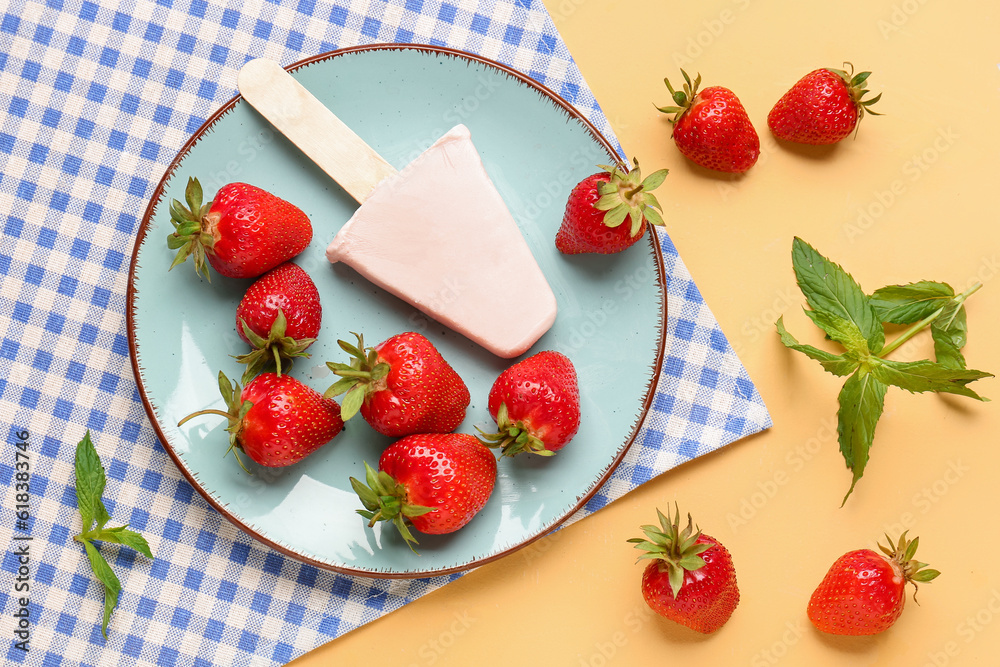 Plate with sweet strawberry ice-cream popsicle on yellow background