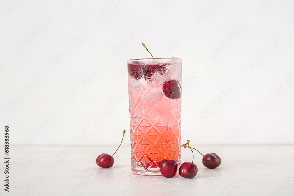 Glass of tasty cherry lemonade on white background