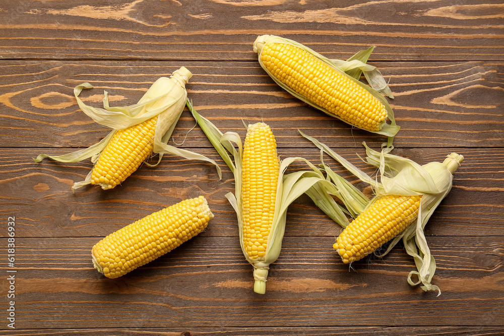 Fresh corn cobs on wooden background