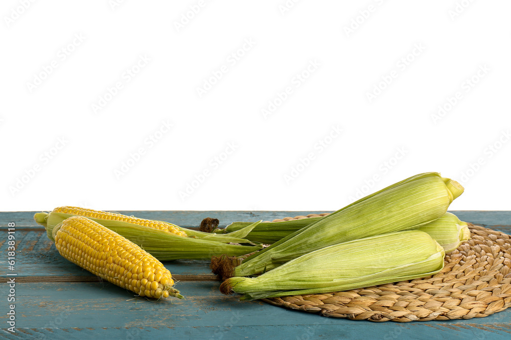 Fresh corn cobs on blue wooden table against white background