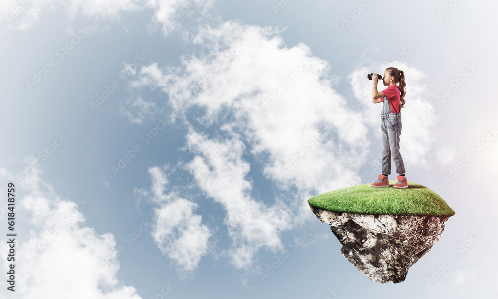 Concept of careless happy childhood with girl looking in binoculars