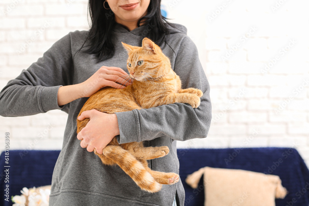 Woman with ginger cat at home, closeup