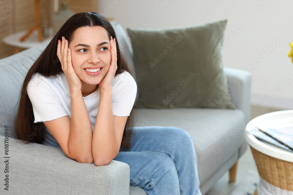 Dreaming young woman on sofa at home