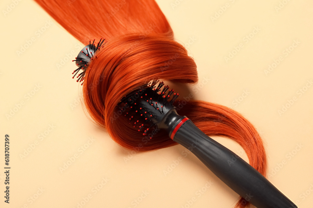 Ginger hair strand with brush on color background, closeup