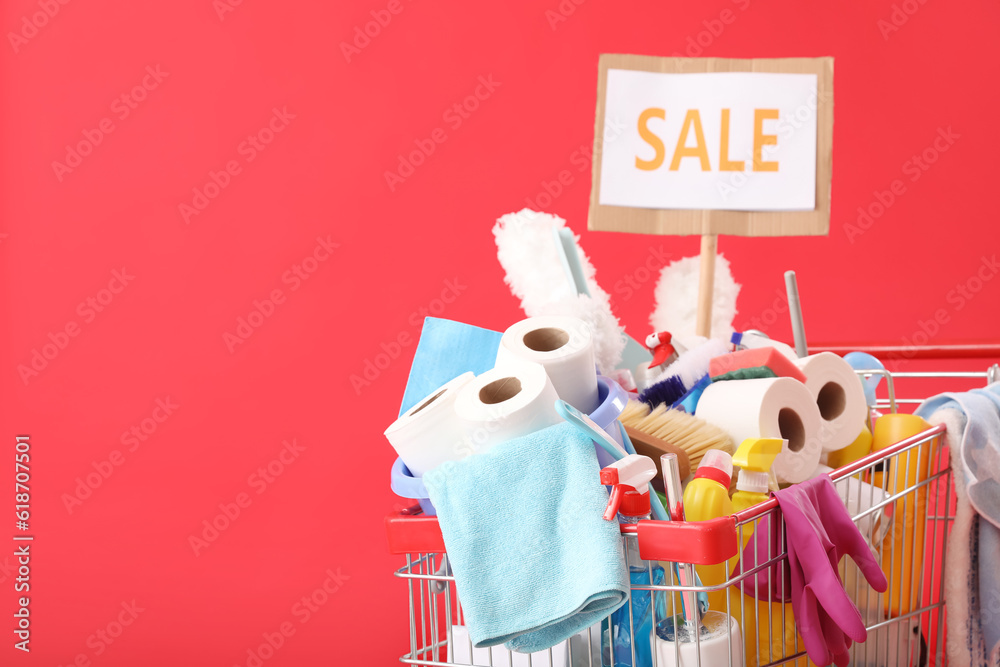 Shopping cart full of cleaning supplies with word SALE on red background