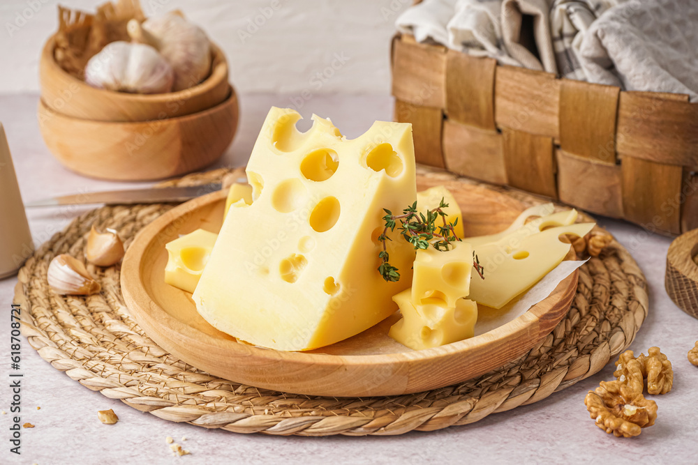 Plate with pieces of Swiss cheese and walnut on white background