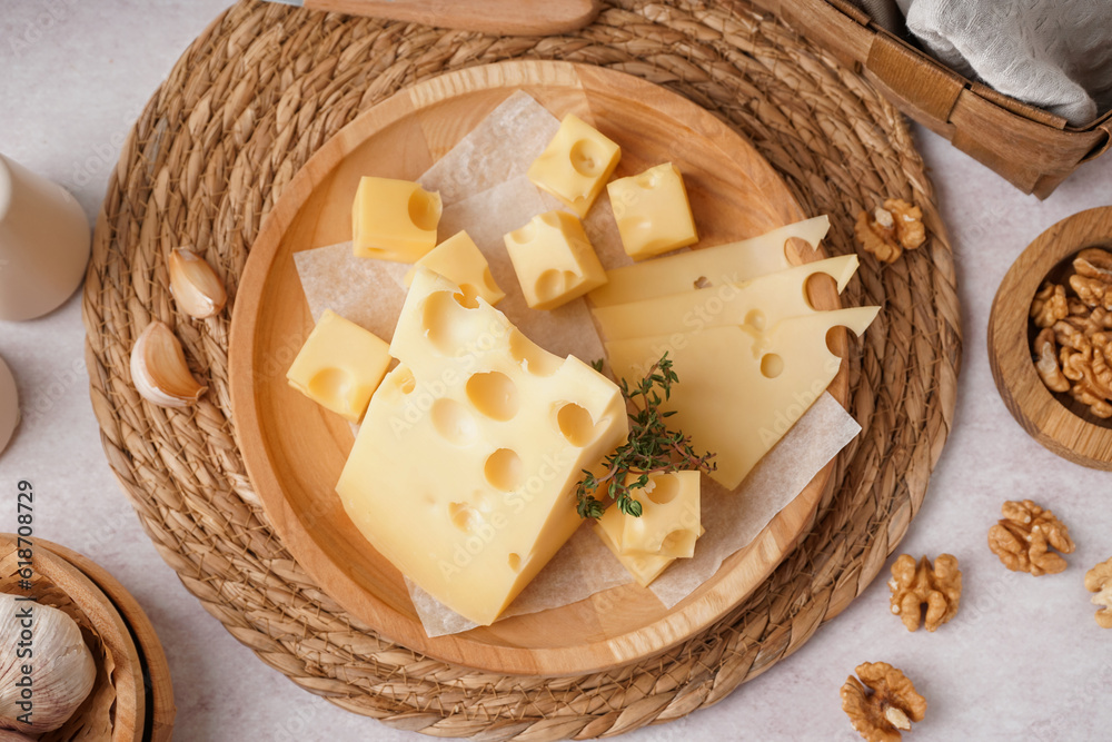 Plate with pieces of Swiss cheese and walnut on white background