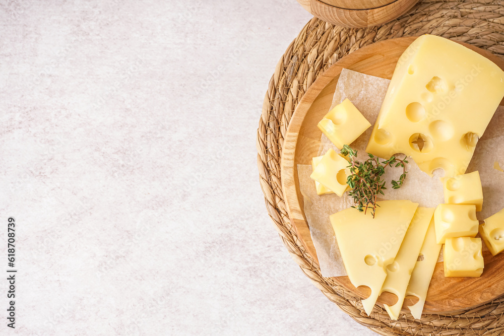 Plate with pieces of Swiss cheese on white background