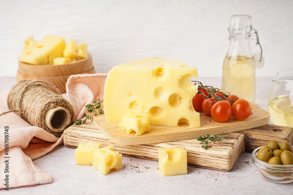 Boards with pieces of Swiss cheese and tomatoes on white table