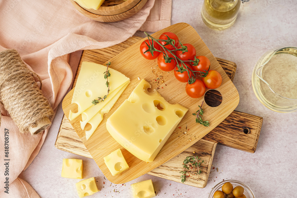 Boards with pieces of Swiss cheese and tomatoes on white table