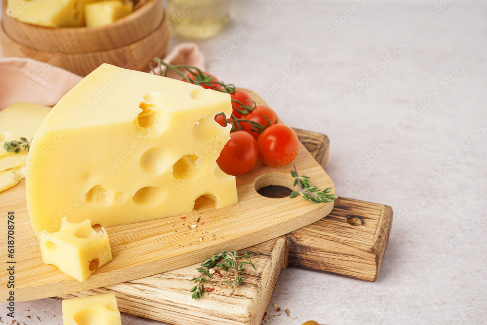 Boards with pieces of Swiss cheese and tomatoes on white table