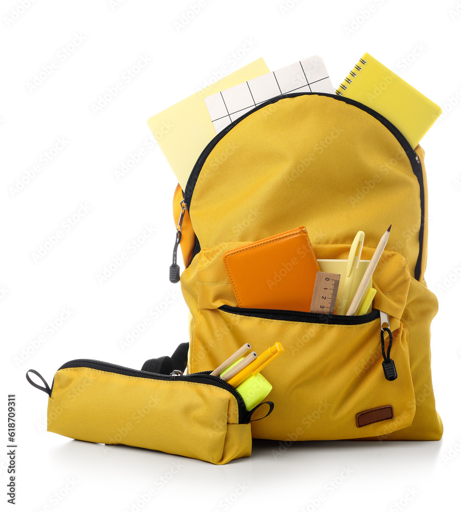 Yellow school backpack with pencil case, notebooks and stationery on white background