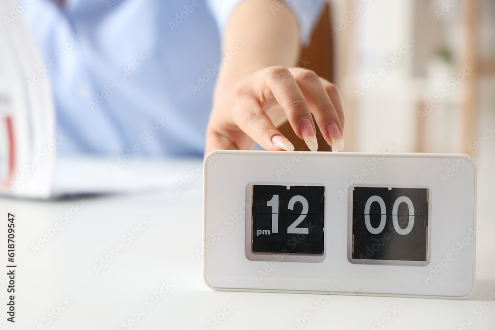 Businesswoman touching clock on table, closeup. Time management concept