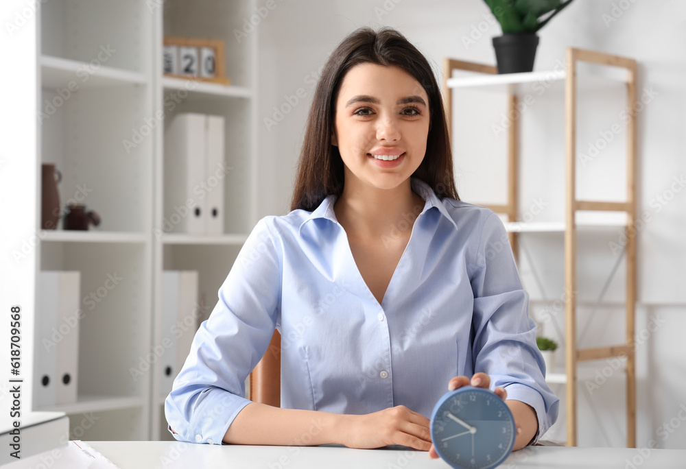 Businesswoman with alarm clock in office. Time management concept