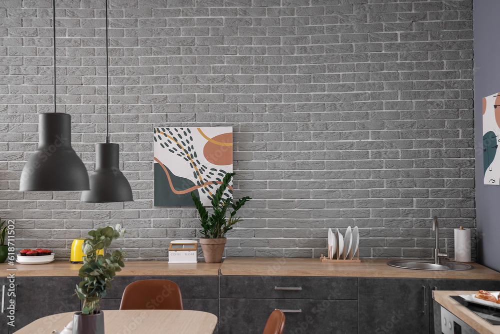 Interior of modern kitchen with dining table and grey counters