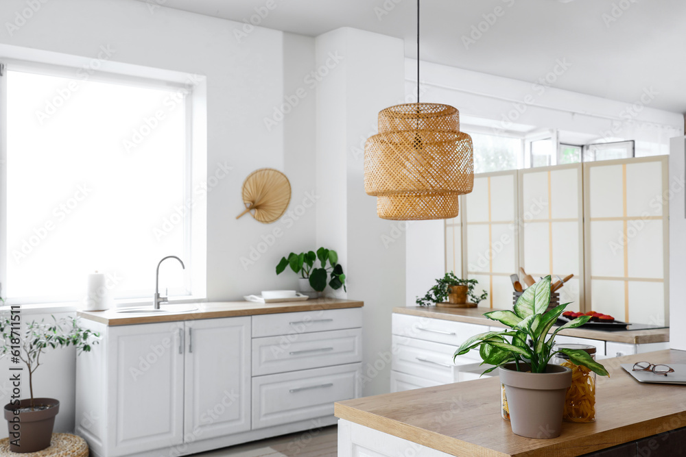 Interior of light kitchen with white counters near window