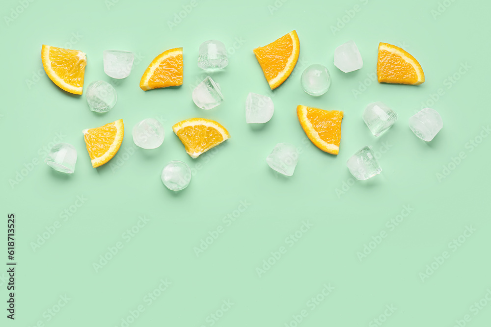 Orange pieces with ice cubes on turquoise background