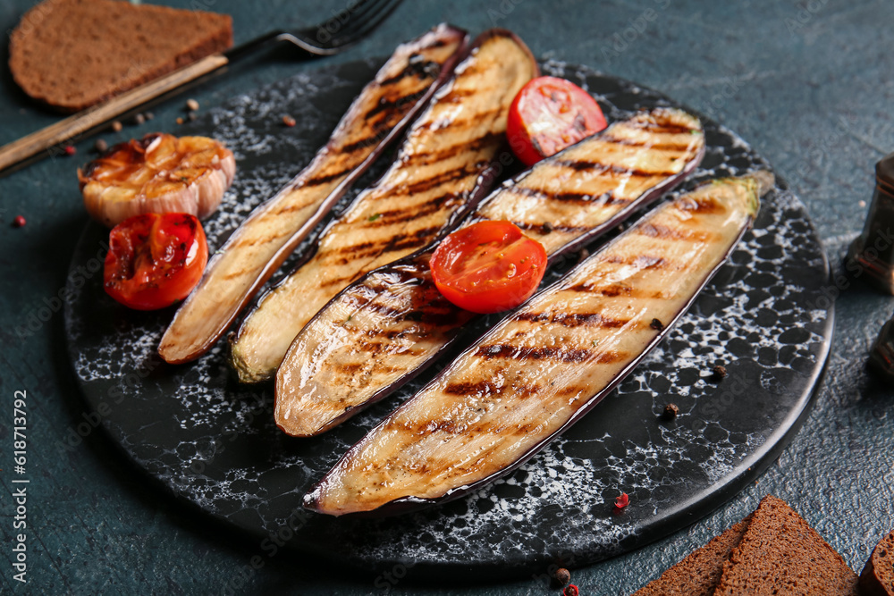 Delicious grilled eggplants and tomatoes on dark background