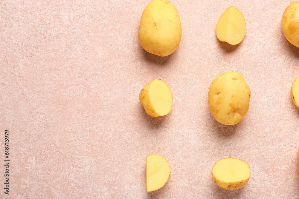 Raw baby potatoes and slices on pink background