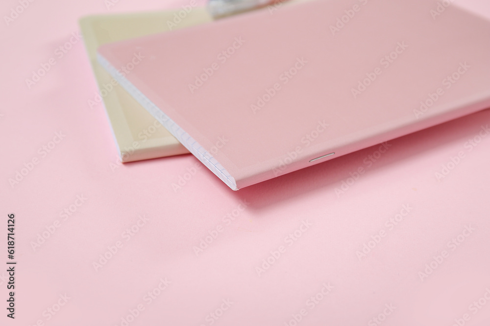 Different notebooks on pink background