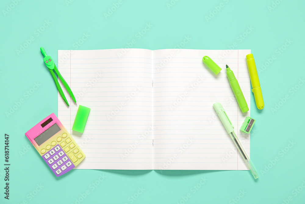 Open notebook with different stationery on turquoise background