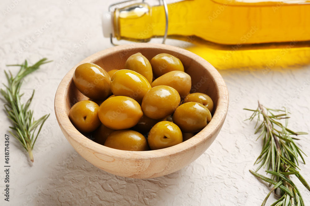 Bowl with ripe olives on light background