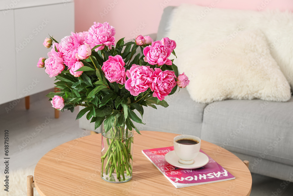 Vase of pink peonies on coffee table with couch in living room