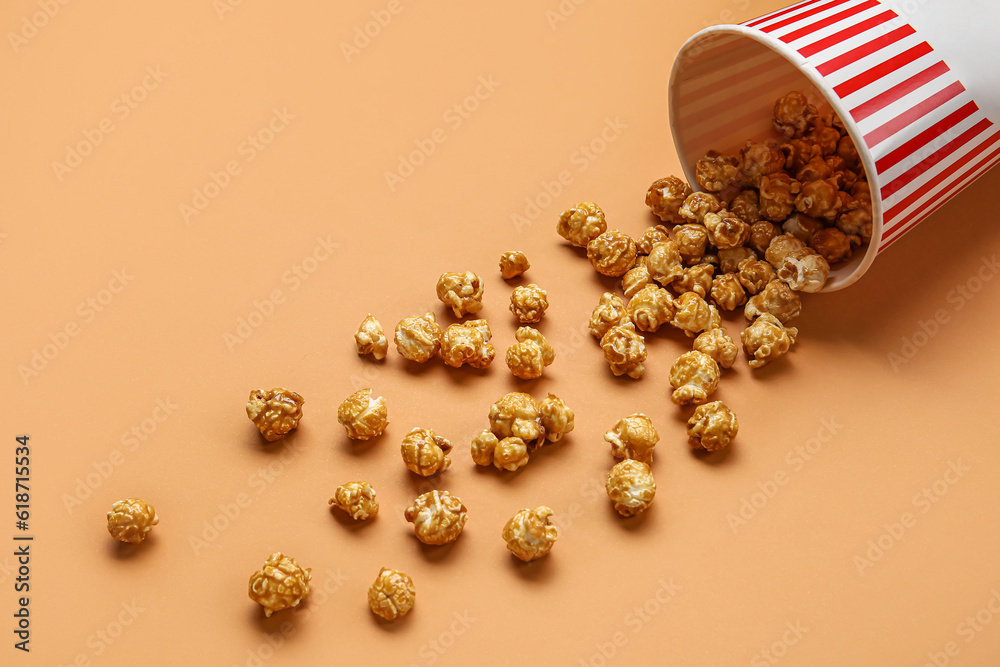 Bucket with tasty popcorn on brown background