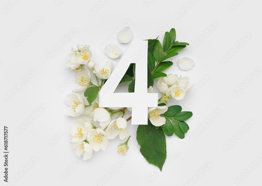 Green leaves and flowers with paper number four on white background