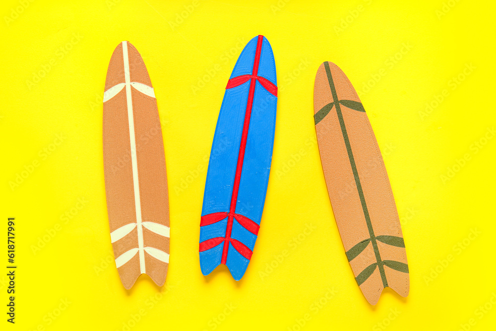 Mini different colorful surfboards on yellow background