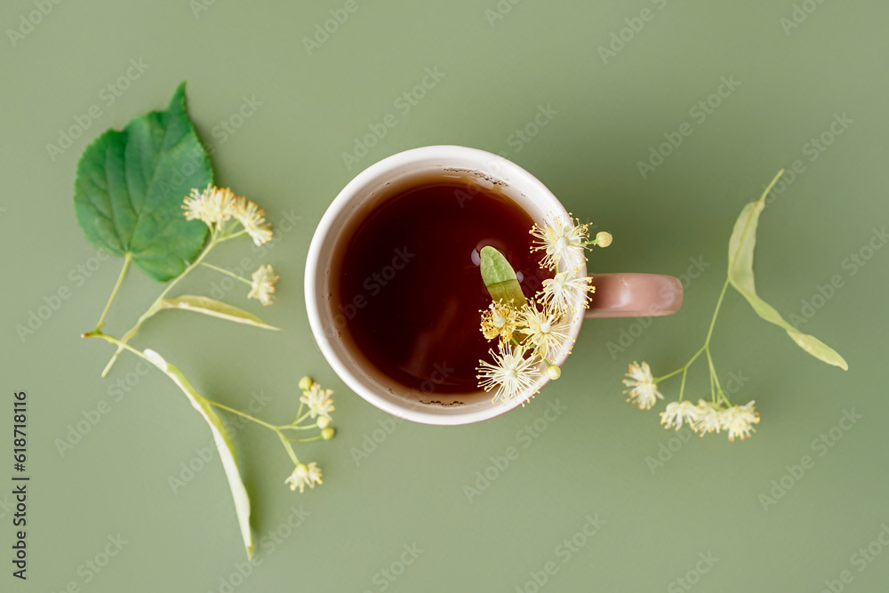 Cup of linden tea on green background