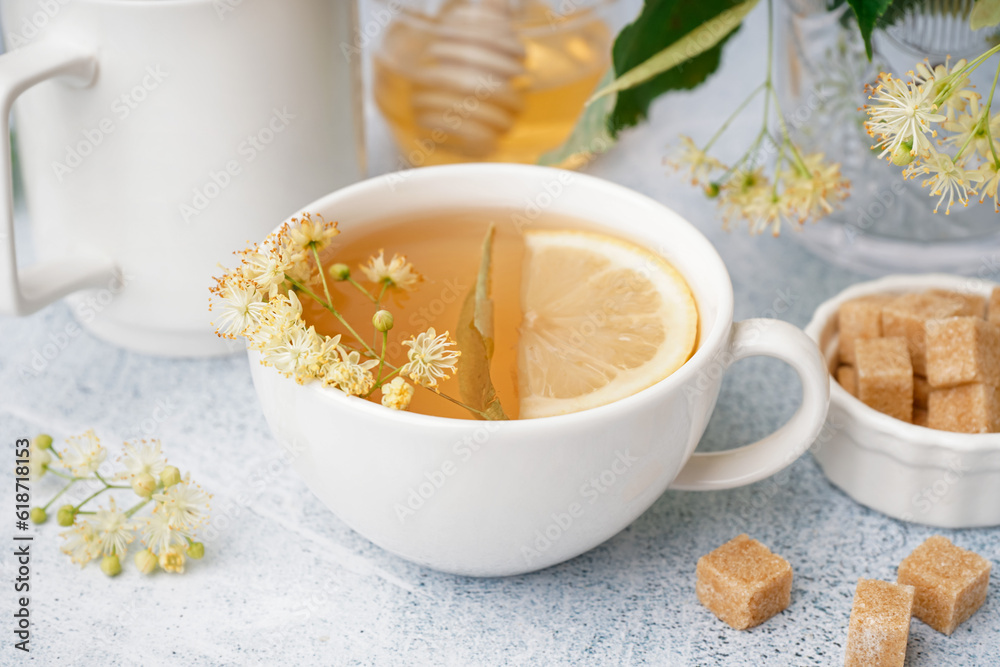 Cups of linden tea with lemon on white background