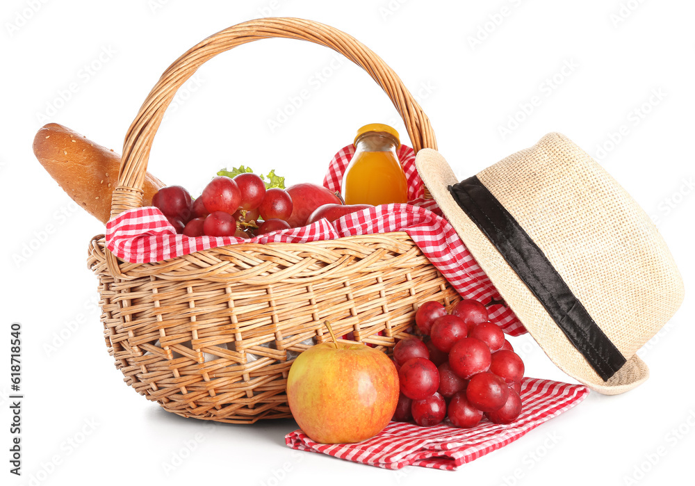 Wicker basket with tasty food for picnic, juice and hat on white background