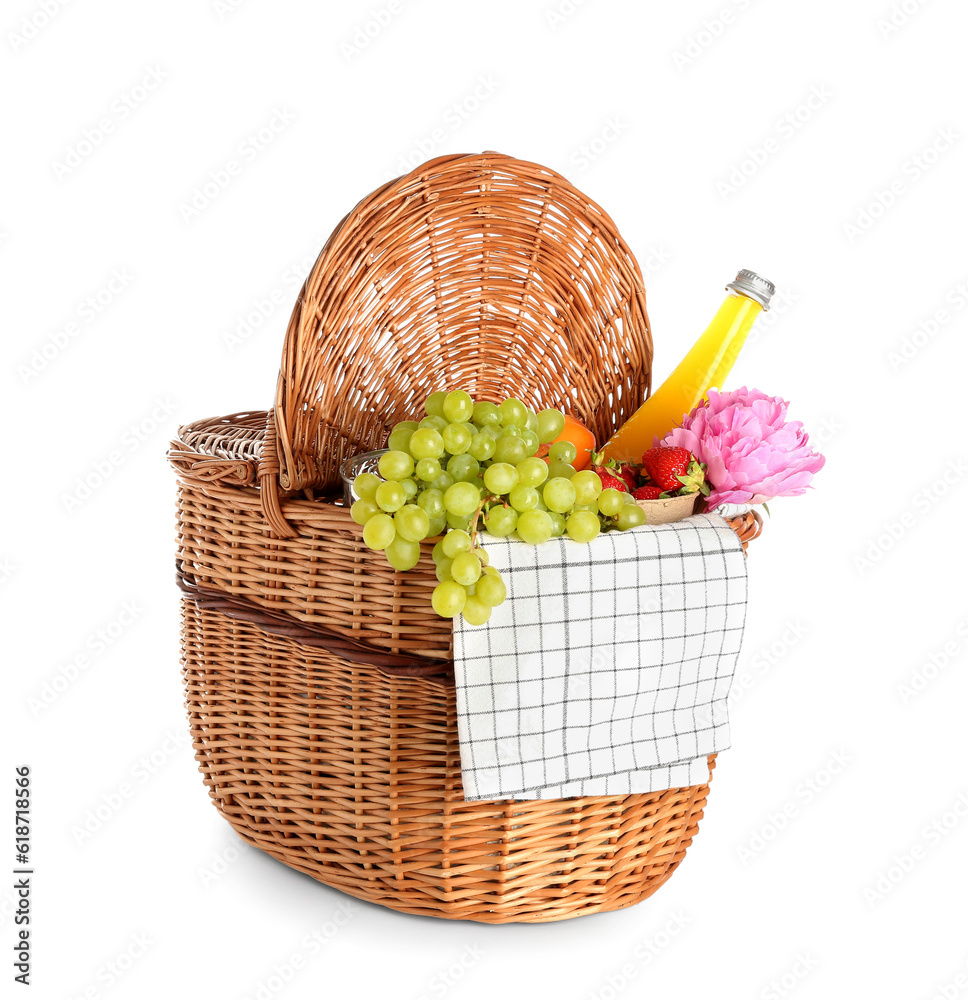 Wicker basket with tasty food for picnic, juice and peony flower on white background