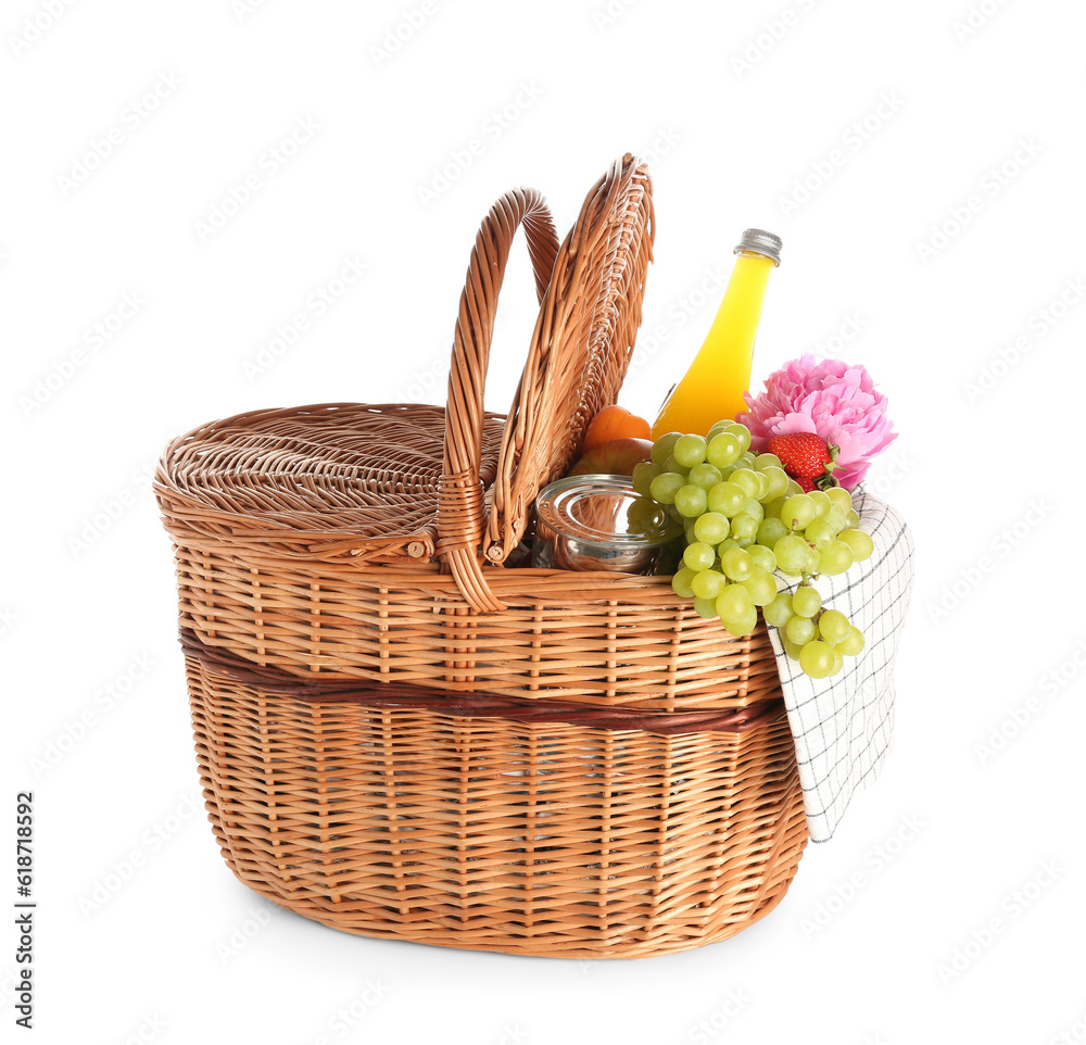 Wicker basket with tasty food for picnic, juice and peony flower on white background