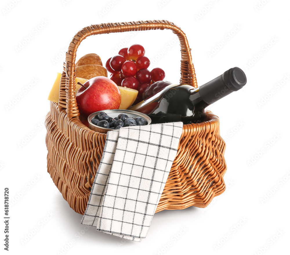 Wicker basket with tasty food for picnic and wine on white background