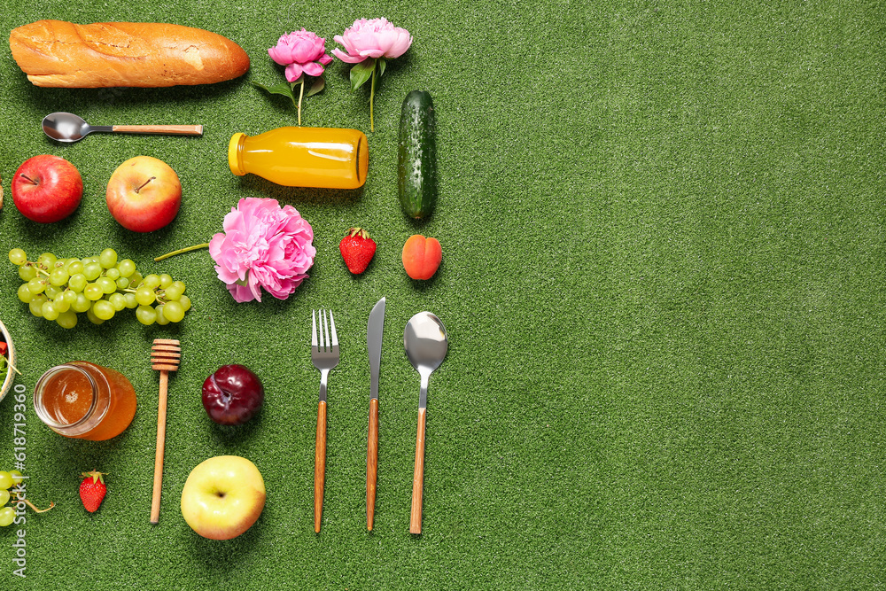 Composition with different tasty food for picnic on green background