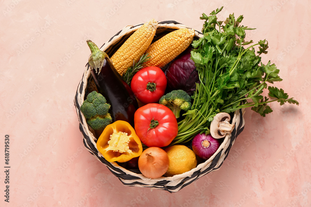 Basket with fresh ripe vegetables on beige background