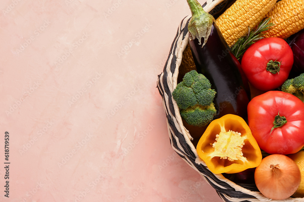 Basket with fresh ripe vegetables on beige background, closeup