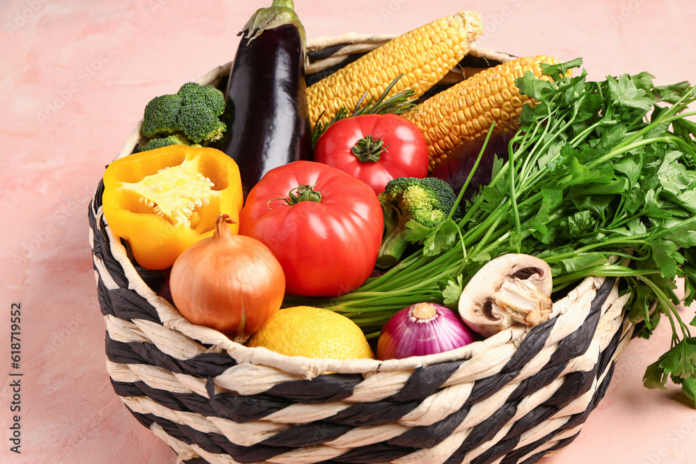 Basket with fresh ripe vegetables on beige background, closeup