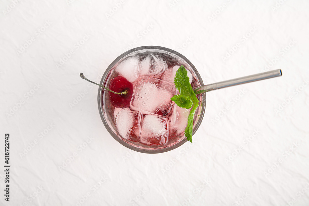 Glass of tasty cherry lemonade with mint on white background