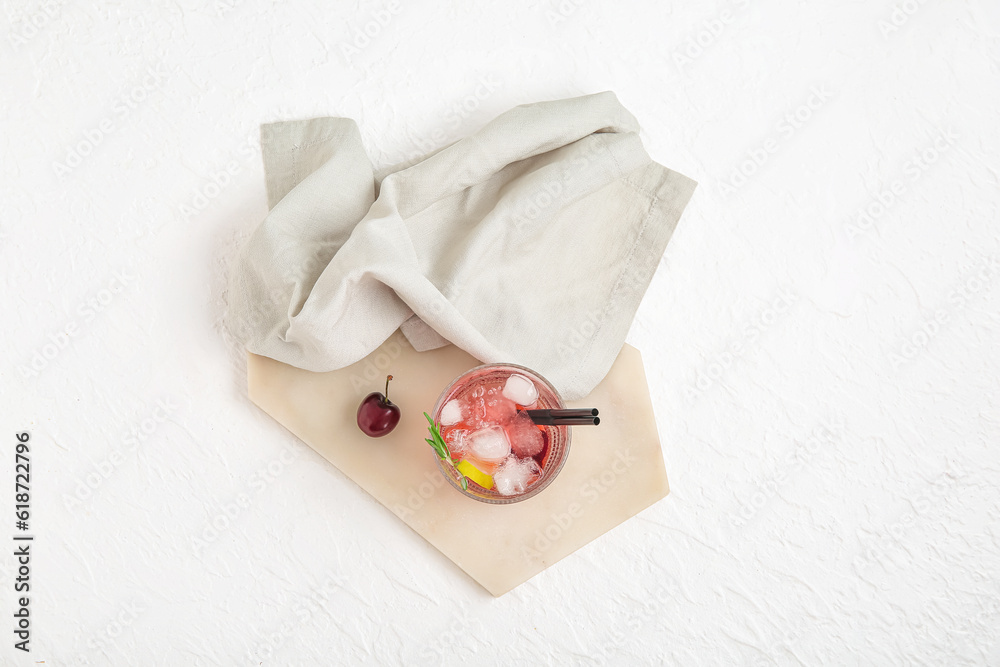 Board with glass of tasty cherry lemonade and rosemary on white background