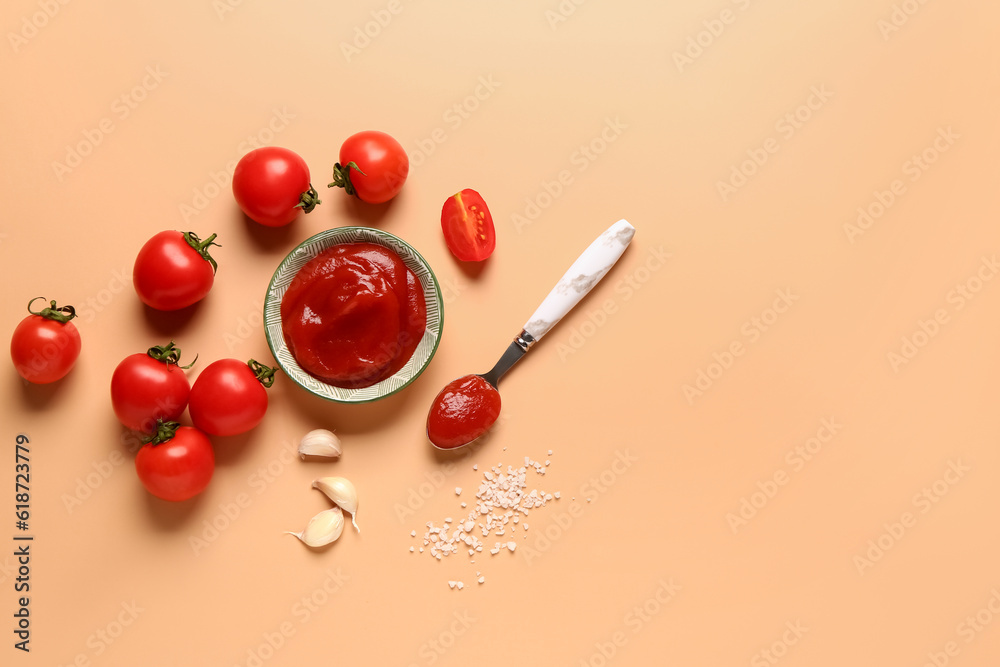 Bowl with tomato paste and fresh vegetables on orange background