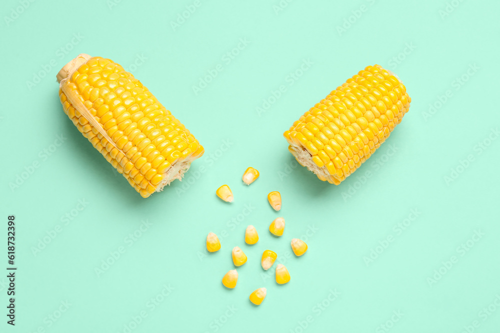 Cut fresh corn cobs and seeds on turquoise background