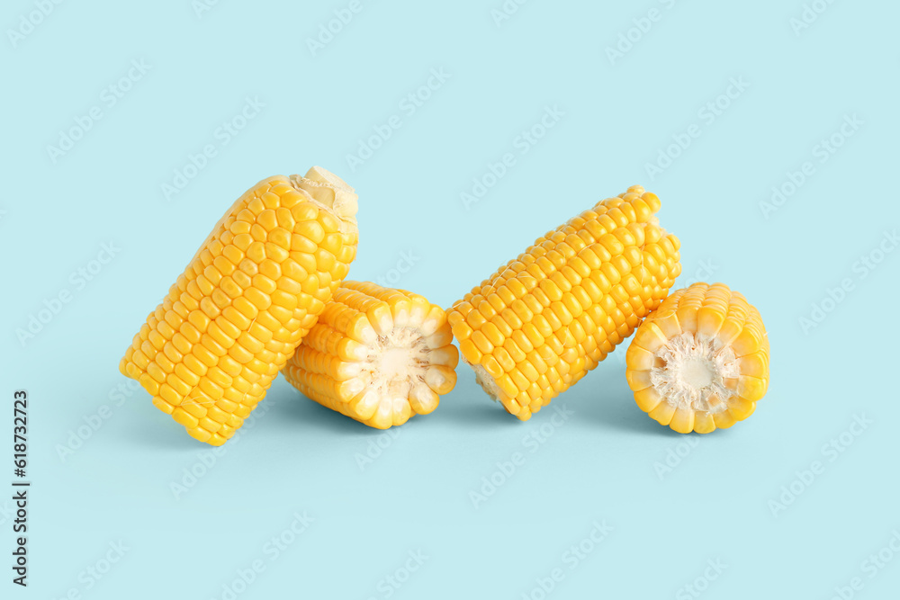 Cut fresh corn cobs on blue background