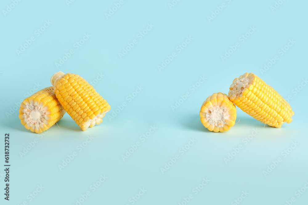 Cut fresh corn cobs on blue background