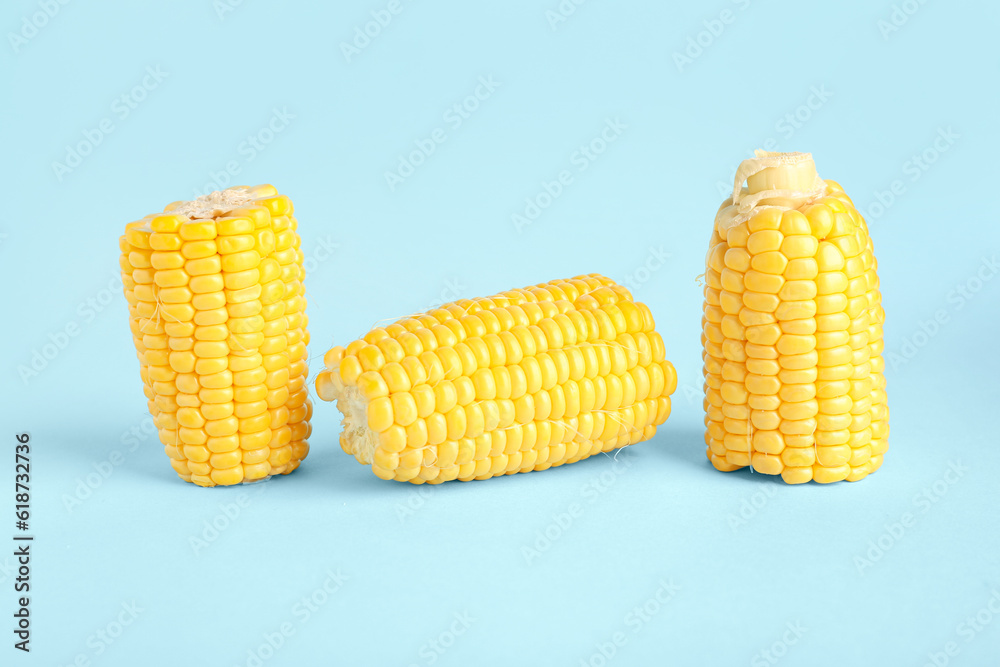 Cut fresh corn cobs on blue background