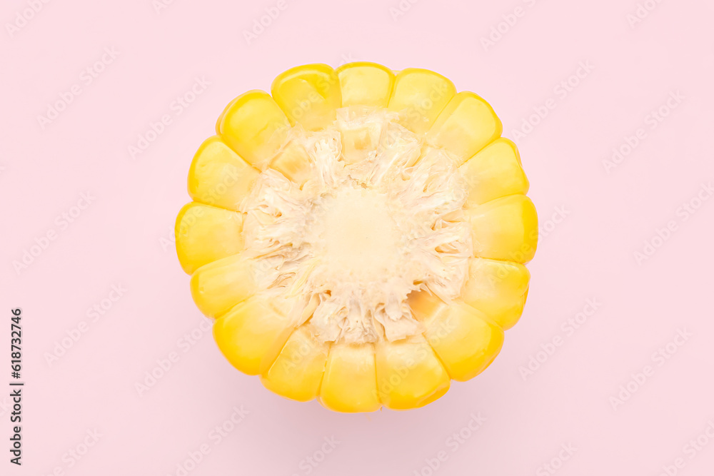 Cut fresh corn cob on pink background