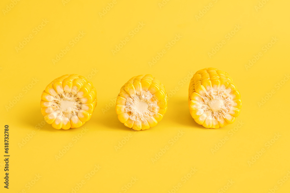 Cut fresh corn cobs on yellow background